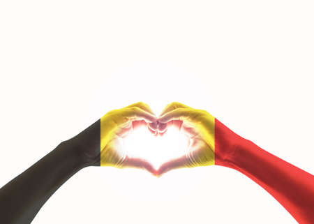 Belgian black yellow red flag pattern on people heart shaped hands (clipping path) on white backgroundの写真素材