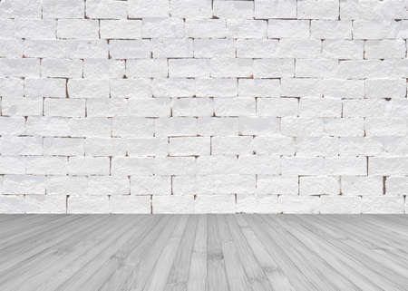 Grunge old aged brick wall painted in white color with wooden floor textured background in light...