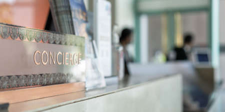 Concierge service counter of hotel, restaurant or apartment's front desk in luxury reception hall in Thailand with staff working for serving tourist guest or check-in customersの写真素材
