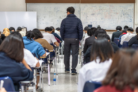 Bangkok, Thailand - December 6, 2019: School exam room with teacher (invigilator) monitoring...