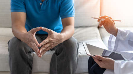 Men's health disease, on prostate cancer or mental illness concept with male patient having consultation with doctor or psychiatrist working on diagnostic examination in medical clinic or hospitalの写真素材