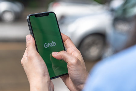 BANGKOK, THAILAND - October 12, 2019: Grab app, application on smartphone on street traffic for calling, Grabbike (bike), Grabtaxi (taxi), Grabcar, express delivery, Grabfood (Food delivery) serviceのeditorial素材