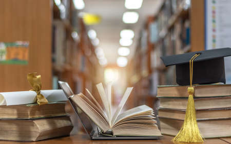 Online education course, E-learning class and e-book digital technology concept with pc computer notebook open in blur school library or classroom background among old stacks of book, textbook の写真素材