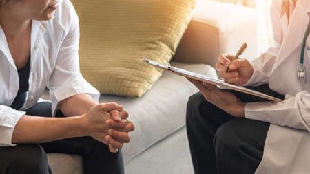 Menopause woman, stressful patient consulting with doctor or psychiatrist who diagnostic examining on obstetric - gynaecological female illness, or mental health in medical clinic or hospitalの写真素材