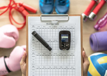 Diabetes monitoring with blood sugar test, glocuse measurement for diabetic disease awareness and control for analyzing insulin-deficient illness patient with exercise sport equipment backgroundの写真素材