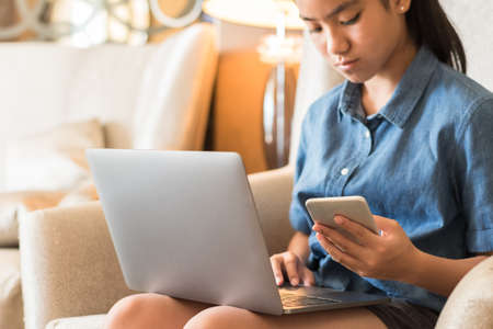 Online education digital lifestyle young teenager student girl studying e-learning class school course using computer and mobile smart phone working on internet communication technology from homeの写真素材