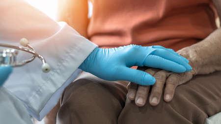 Parkinson's disease patient, Arthritis hand and knee pain or mental health care concept with geriatric doctor consulting examining elderly senior aged adult in medical exam clinic or hospitalの写真素材