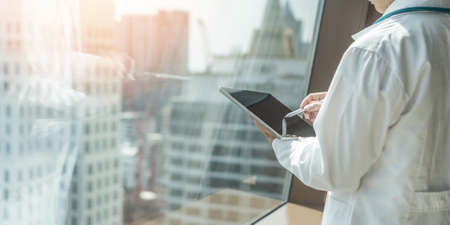 Telehealth, telemedicine medical service and online tele-health care concept with doctor working on digital tablet, computer internet technology examing and analyzing patient health in hospitalの写真素材