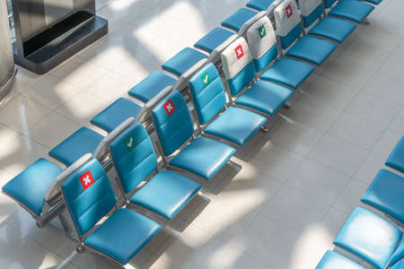 Social distancing for travel safety with seat allocation and sitting distance allowance warning sign on empty chairs in airport or bus terminal during covid-19, coronavirus pandemic with no peopleの写真素材