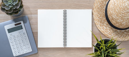Notebook open blank note book paper page on work desk from top view for template mockup with computer laptop, calculator, travel hatの写真素材