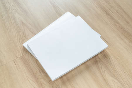 Book cover mockup with blank white front paper page a4 paperback mock up for catalog, magazine, menu, booklet, notebook, portfolio design template on wood table backgroundの写真素材