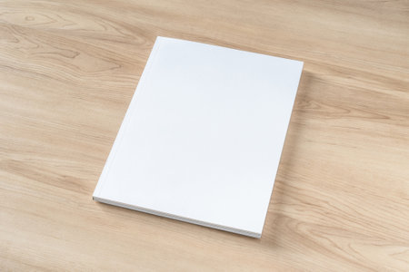 Book cover mockup with blank white front paper page a4 paperback mock up for catalog, magazine, menu, booklet, notebook, portfolio design template on wood table backgroundの写真素材
