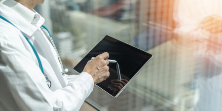 Telehealth and telemedicine by medical doctor or physician consulting patientâs health online using mobile digital tablet in hospital for professional emergency tele-healthcare assistance serviceの写真素材