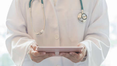 Medical doctor with telehealth consulting patientâs health online using mobile digital tablet for telemedicine in hospital for professional emergency tele-medicine healthcare assistance serviceの写真素材