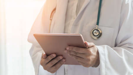 Medical doctor with telehealth consulting patientâs health online using mobile digital tablet for telemedicine in hospital for professional emergency tele-medicine healthcare assistance serviceの写真素材
