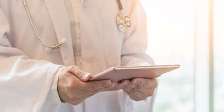 Medical doctor with telehealth consulting patientâs health online using mobile digital tablet for telemedicine in hospital for professional emergency tele-medicine healthcare assistance serviceの写真素材