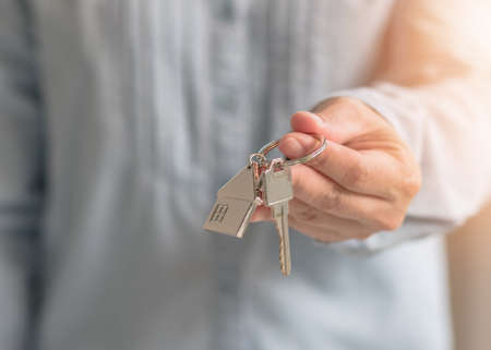 House key in landlord, real estate sale person or home Insurance broker agent hand giving to tenant,...
