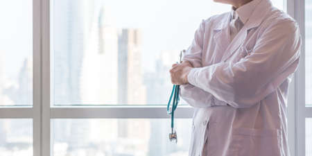 Medical doctor or physician in clinic office or hospital lab for patient trust, professional healthcare service, health exam check up record with city office building backgroundの写真素材