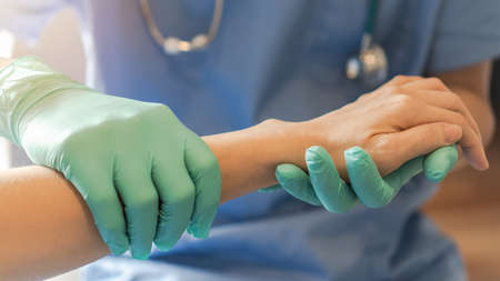 Surgeon, surgical doctor holding patient hand in professional ER emergency operation room for health care trust, medical anesthetic safety by anesthetist or anesthesiologist healthcare support conceptの写真素材
