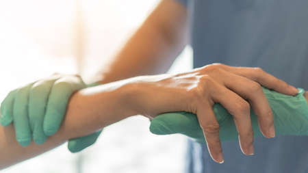 Surgeon, surgical doctor holding patient hand in professional ER emergency operation room for health care trust, medical anesthetic safety by anesthetist or anesthesiologist healthcare support conceptの写真素材