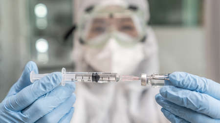 Vaccine for  virus vaccination, medical immunization with doctor or scientist in PPE protective glove in medical lab or researcher research laboratory for  virus disease immunityの写真素材