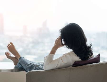 Anxiety disorder menopause woman, stressful depressed, panic attack person with mental health illness, headache and migraine pain sitting on armchair in domestic homeの写真素材