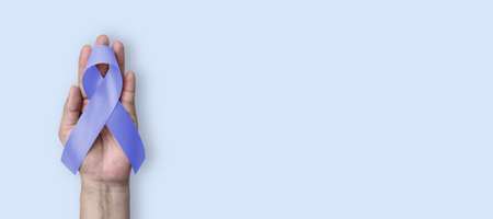 Esophageal and stomach cancer awareness month, and Gastroesophageal Acid Reflux Disease (GERD) Awareness Week with Periwinkle color ribbon on hand supportの写真素材