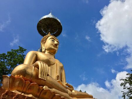 Golden buddha statue with bluesky and cloudの写真素材