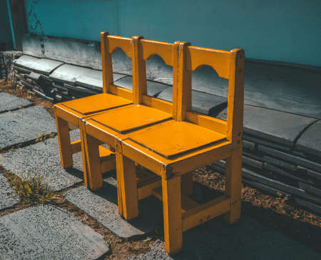 wooden chairs, yellow, three in a rowの写真素材