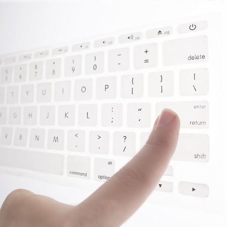 finger presses the enter key on a keyboard の写真素材