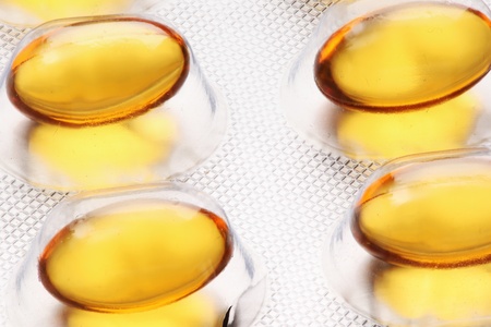 fish oil pills over the white background 