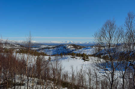 Deep snow covered mountain range on a sunny day in Northern Norway の写真素材