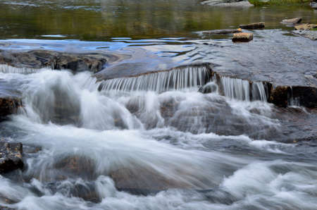 mountain lake river stream with waterfall downstream in summer