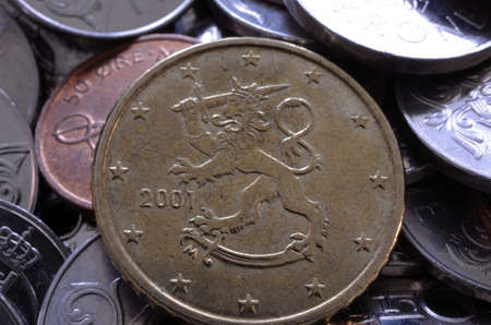 Euro coin in the middle of a norwegian coin pile macro photoの写真素材