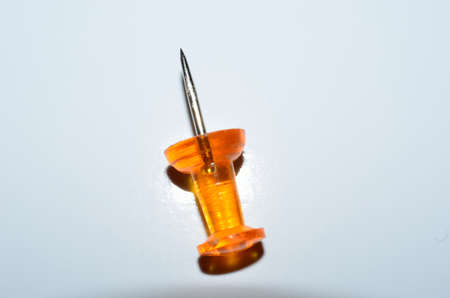 bright orange pin on white の写真素材