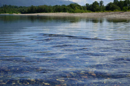 Fresh river water flowing over a stoneの写真素材