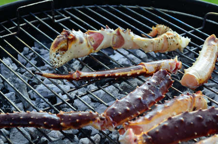Barbecuing some fantastic raw red king crab  legs and claws outside in the warm summer airの写真素材
