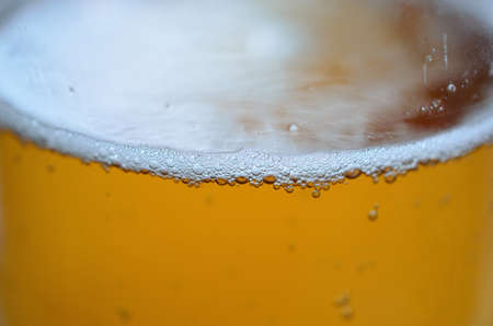 Glass of beer macro photo with bubbles racing to the surface macro photoの写真素材