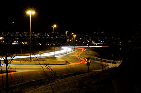 bright white and red car traffic lights on lit city road at night timeの写真素材