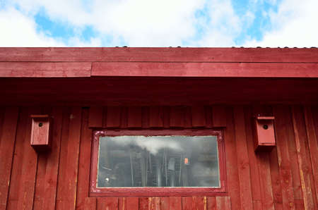 red barn wall with two bird houses