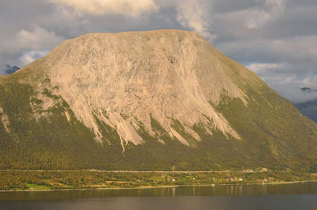 majestic mountain with road and settlement underneathの写真素材