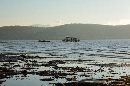 old ship wreck in fjord with tromsoe city island in background