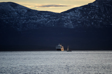 hurtigruten and sailboat in tromsoe fjord with new snow mountain in the backgroundのeditorial素材