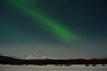 aurora borealis, northern light over winter landscape and snowy mountainの写真素材