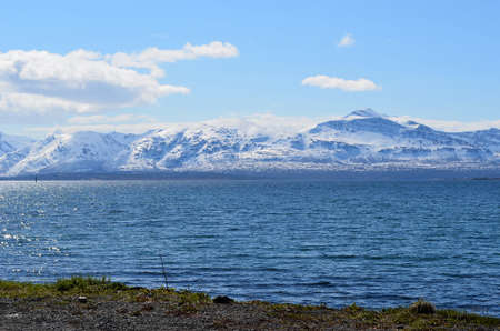 snowy mountain, blue fjord and blue summer sky sunlightの写真素材