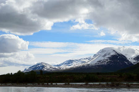 majestic snowy mountain and river landscape in early summerの写真素材