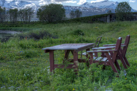 old chair and table on grassy field near seashore