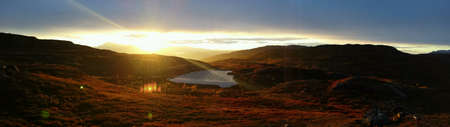 Sunshine over mountain lake and colourful autumn mountain landscape natureの素材