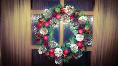 Christmas wreath on wooden door in holiday timeの素材