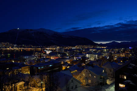 tromso city at winter snowy night with light,traffic,fjord and motion with mainland in backgroundのeditorial素材